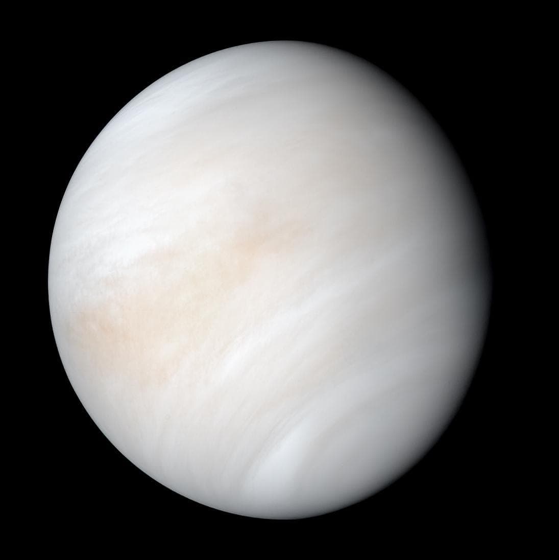 Venus as a pale cream globe wrapped in soft swirls of cloud.